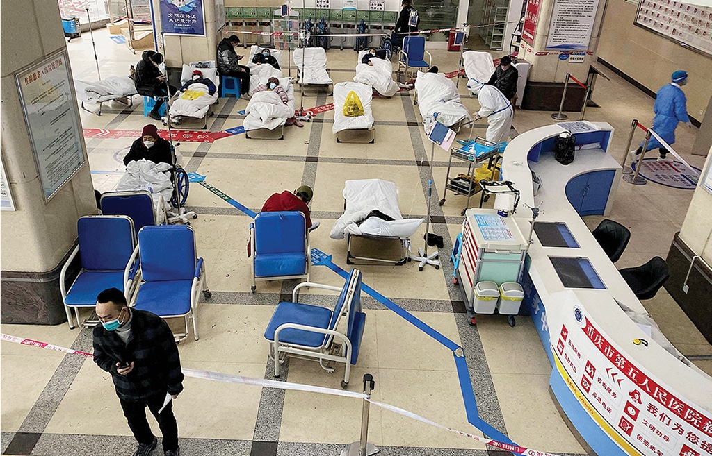 CHONGQING, China: A man stands in front of a cordoned-off area where COVID-19 patients lie on hospital beds in the lobby of the Chongqing No. 5 People's Hospital on Dec 23, 2022. - AFP