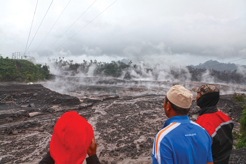 LUMAJANG, Indonesia: Villagers watch hot smoke from the ground following Mount Semeru's volcanic eruption in Lumajang, East Java on December 4, 2022. - AFP