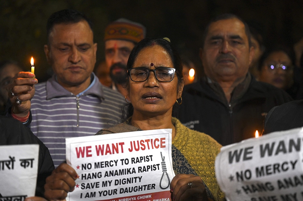 NEW DELHI: Asha Devi, mother of the 2012 Delhi gang rape victim, along with people, holds candles and placards during a vigil on Dec 16, 2022 on the tenth anniversary of the heinous gang rape of the young woman. – AFP