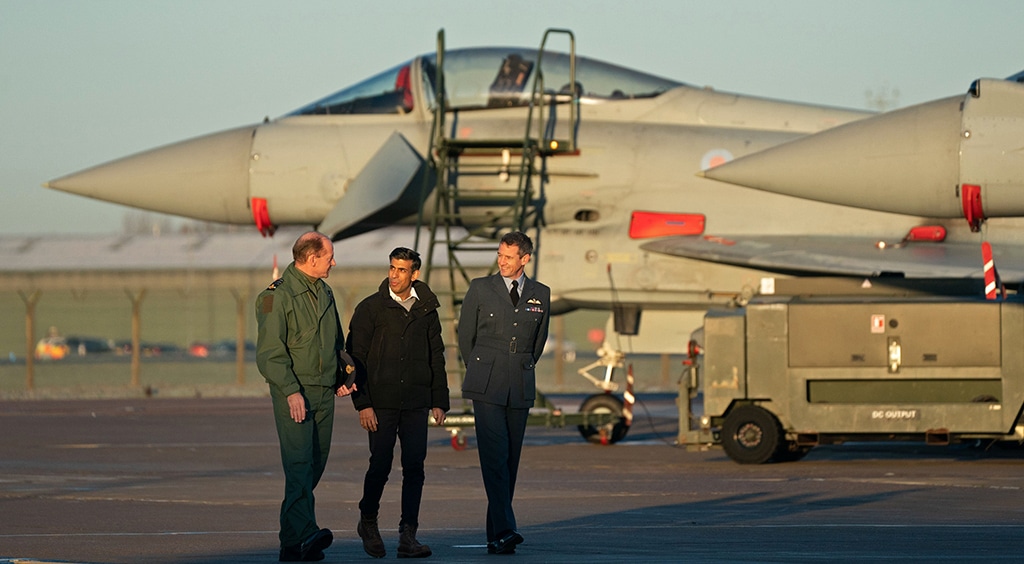 LINCOLN, UK: Britain's Prime Minister Rishi Sunak (center) talks with Britain's Air Chief Marshal Mike Wigston (left) and RAF Coningsby Station Commander Billy Cooper, as they pass Typhoon fighter jets, during his visit to Royal Air Force RAF Coningsby, near Lincoln, eastern England, on December 9, 2022, following the announcement that Britain will work to develop next-generation fighter jets with Italy and Japan. – AFP
