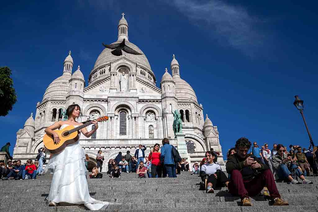 Eli Jadelot, performs in a wedding dress in front of the Sacre Coeur in Paris.— AFP photos 