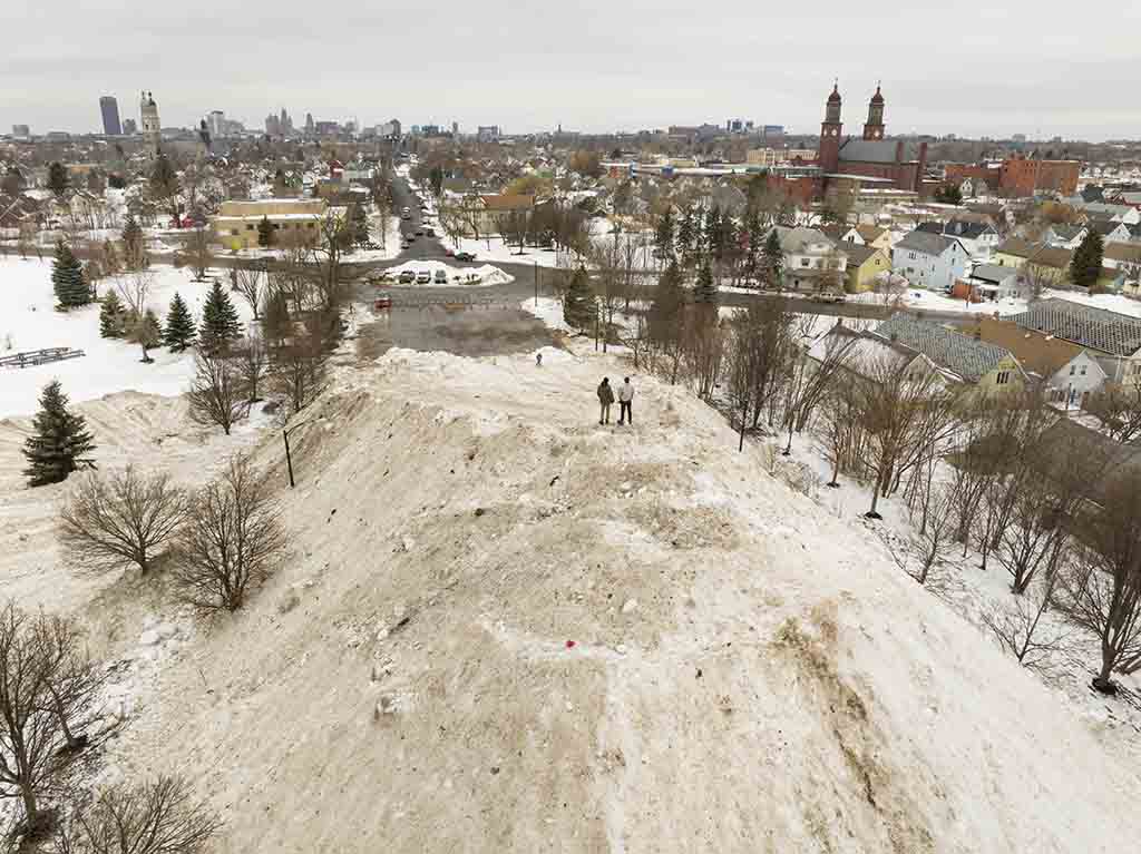 Residents take in the view from atop a gigantic snow pile in front of Central Terminal in Buffalo, New York.— AFP photos