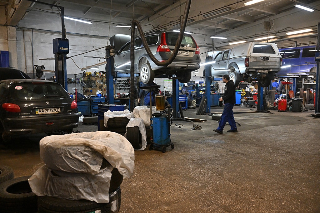 Mechanics work with a pickup trucks in a auto repairing shop in Ukrainian capital of Kyiv.— AFP photos