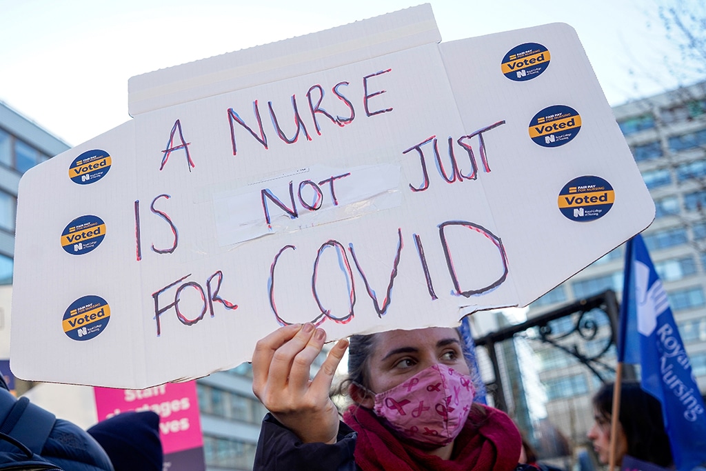 LONDON: File photo shows a healthcare worker holds a placard at a picket line during a strike, outside St Thomas' Hospital in London. Industrial action looked set to intensify Monday as Britain's largest teaching and nursing unions announced further walkouts over pay, while the government sought to clamp down on strikes. - AFP