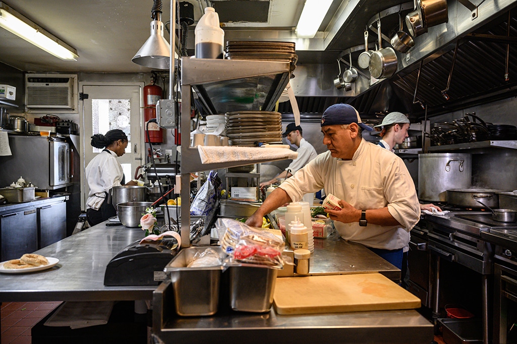 NEW YORK: File photo shows, chefs prepare food in the kitchen of the Amali restaurant in New York. The dominant US services sector contracted for the first time in more than two years, survey data showed, as business activity slumped. – AFP
