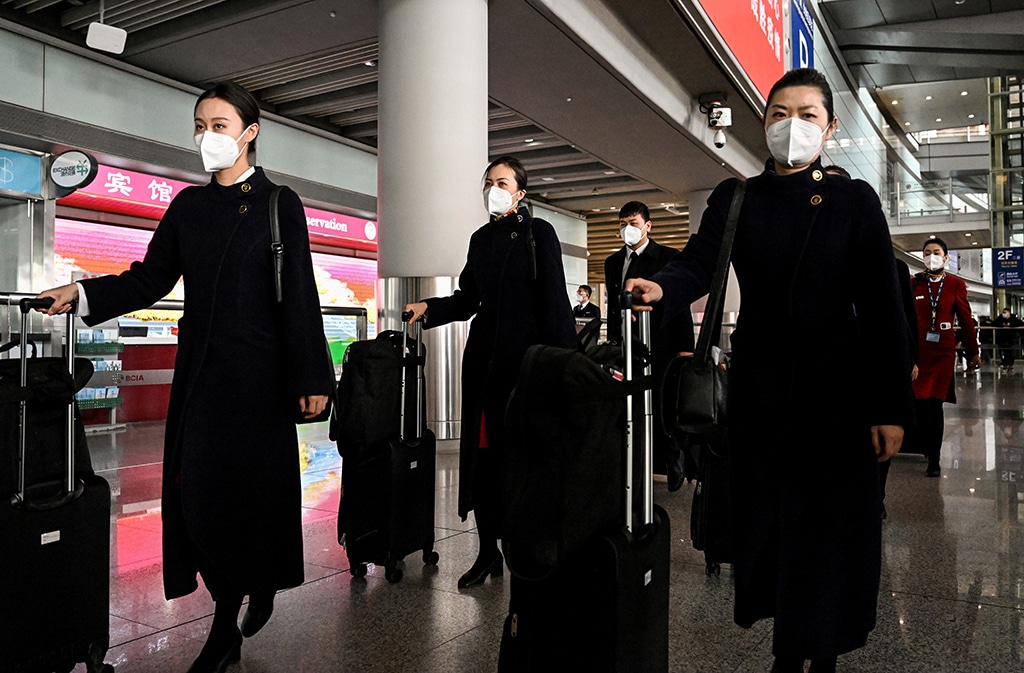BEIJING: Flight attendants walk at the arrival area at the Beijing Capital International Airport in Beijing on January 8, 2023.- AFP