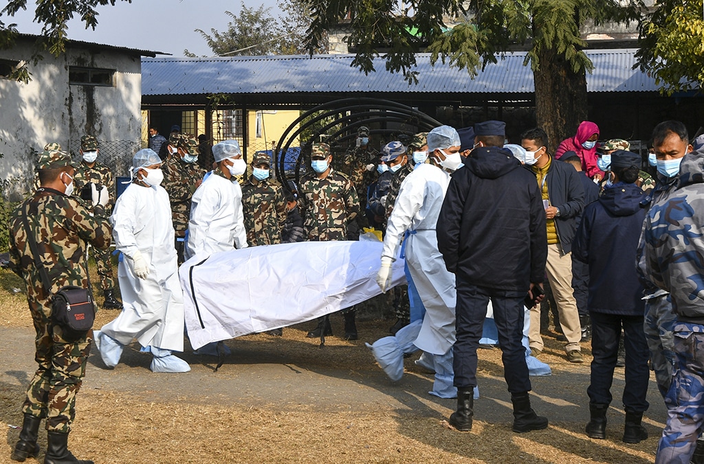 POKHARA: Nepal's army and volunteers carry the body of a victim who died in a Yeti Airlines plane crash in Pokhara on January 17, 2023. The Yeti Airlines ATR 72 plummeted into a steep gorge, smashed into pieces and burst into flames as it approached the central city of Pokhara. - AFP