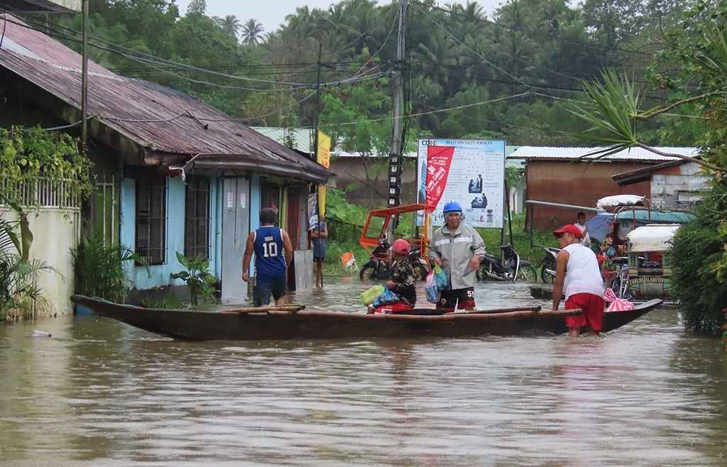 CATUBIG: In this handout photo from Catubig Municipal Information Office taken on January 10, 2023 shows people riding a boat in a flooded area in Catubig, due to the heavy rains brought by a low pressure area. – AFP