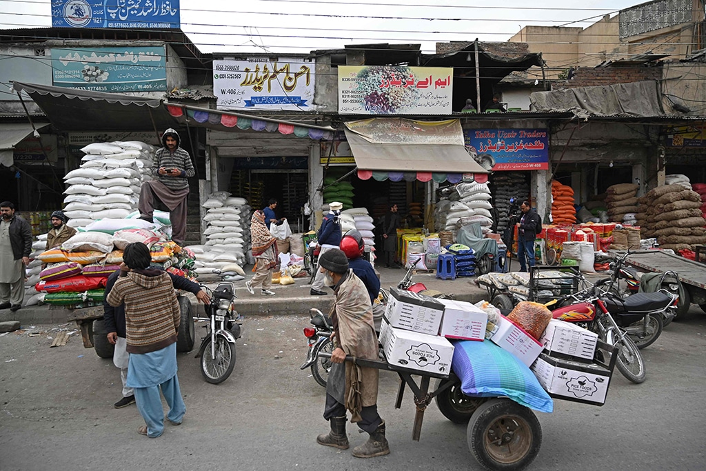 RAWALPINDI: Labourers pull carts loaded with grain sacks at a grocery market in Rawalpindi on January 9, 2023. – AFP