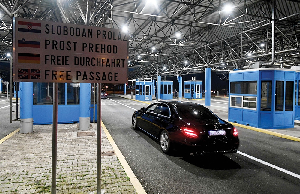 Vehicles pass without stopping at the Bregana border crossing between Croatia and Slovenia on January 1, 2023. - Croatia on January 1 switched to the euro and entered Europe's passport-free zone -- two major milestones for the country after joining the European Union nearly a decade ago. It is now the 27th nation in the passport-free Schengen zone, the world's largest, which enables more than 400 million people to move freely around its members. (Photo by DENIS LOVROVIC / AFP)