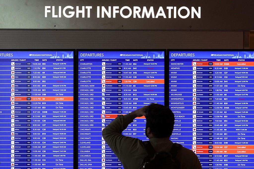 ARLINGTON, Virginia: A traveler looks at a flight information board at Ronald Reagan Washington National Airport on Jan 11, 2023. – AFP