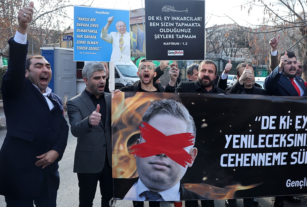ANKARA: Protesters hold a banner bearing a crossed-out picture of Swedish politician Rasmus Paludan during a demonstration outside Sweden's embassy on Jan 21, 2023. — AFP