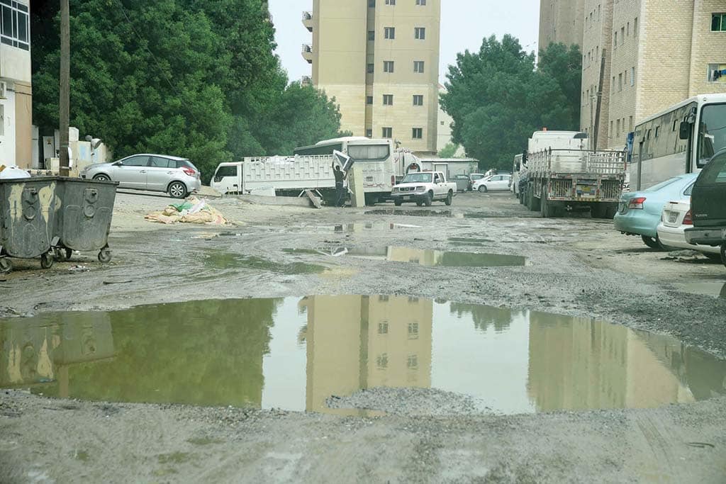 KUWAIT: Large puddles are seen on a potholed road after rainfall in this recent file photo. – Photo by Fouad Al-Shaikh