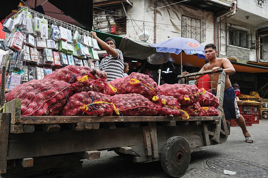 MANILA: In this photo taken on Jan 19, 2023, a worker pushing a cart of onions at a market. – AFP