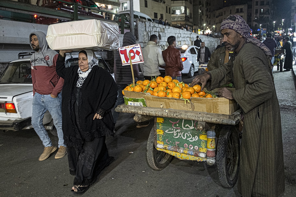 CAIRO: People walk past a hawker selling tangerines along a street in the Azhar district of Egypt's capital on Jan 16, 2023. – AFP