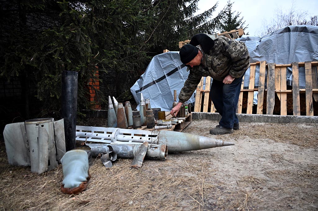 TSIRKUNY: A local resident collects shells of various types of ammunition in Tsirkuny village, Kharkiv region, on January 31, 2023, amid Russia's military invasion on Ukraine. - AFP