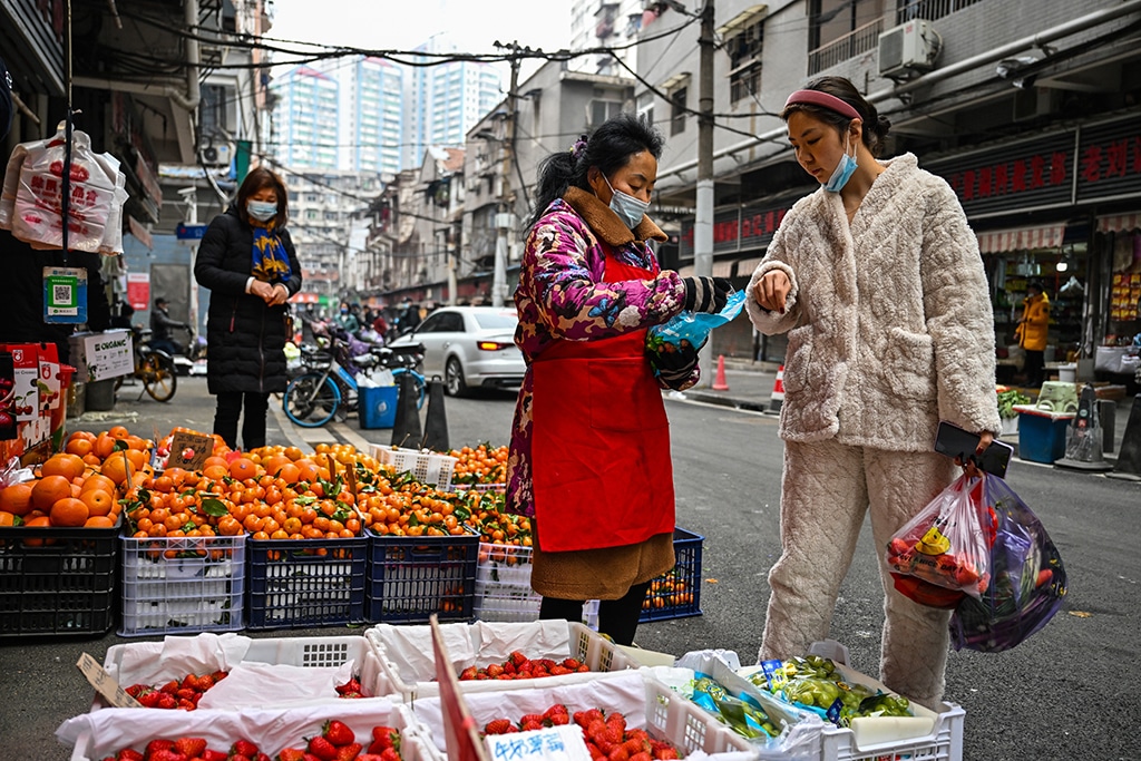 WUHAN: A customer buys fruit at a local market in Wuhan, in China's central Hubei province, on January 23, 2023. – AFP