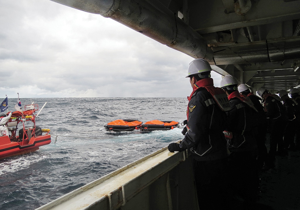 JEJU, South Korea: This handout photo taken on January 25, 2023 and provided by the Korea Coast Guard shows coast guard members searching for missing people after a Hong Kong cargo ship sank off South Korea's southern island of Jeju. - AFP