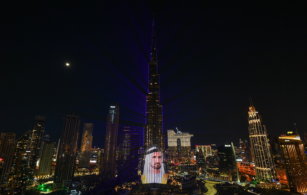 The portrait of UAE's Vice President and Prime Minister Sheikh Mohammed bin Rashid al-Maktoum lights the landmark Burj Khalifa tower at midnight in the Gulf emirate of Dubai on December 31, 2022. (Photo by Ryan LIM / AFP)