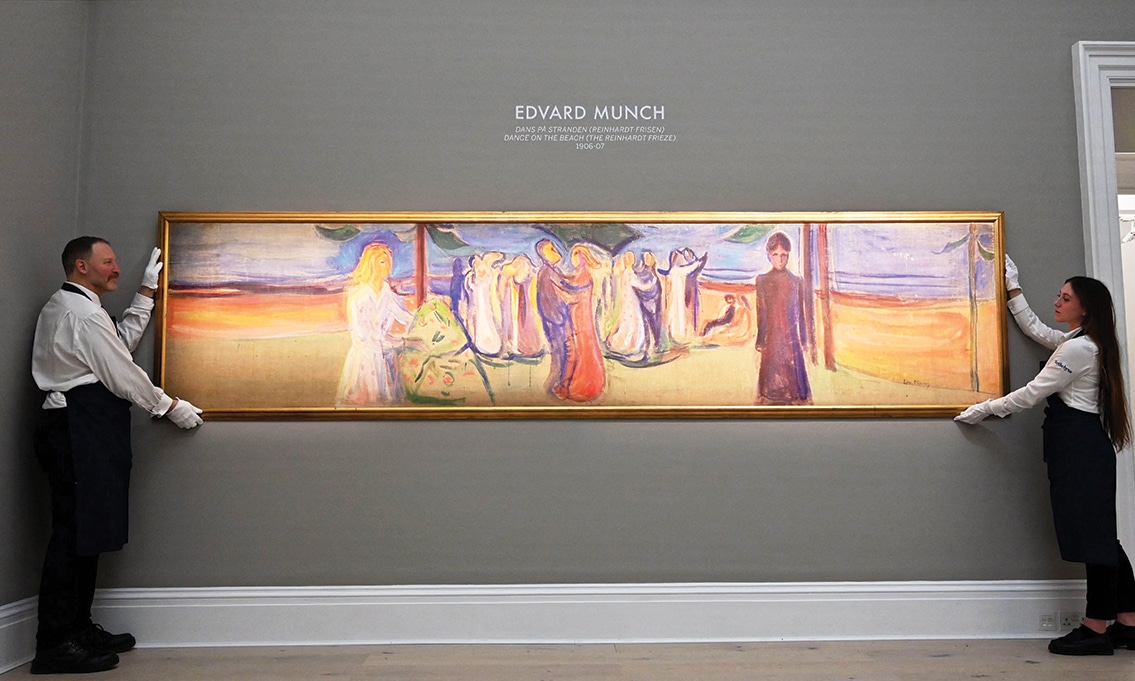 Employees pose with an artwork entitled ‘Dance on the Beach’ (The Reinhardt Frieze) by Edvard Munch, during a photocall at Sotheby’s auction house in central London.— AFP photos