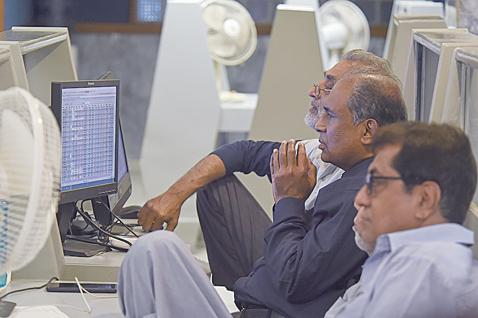 KARACHI: Stockbrokers look at the latest share prices at the Pakistan Stock Exchange (PSE) in Karachi on February 9, 2023. - AFP