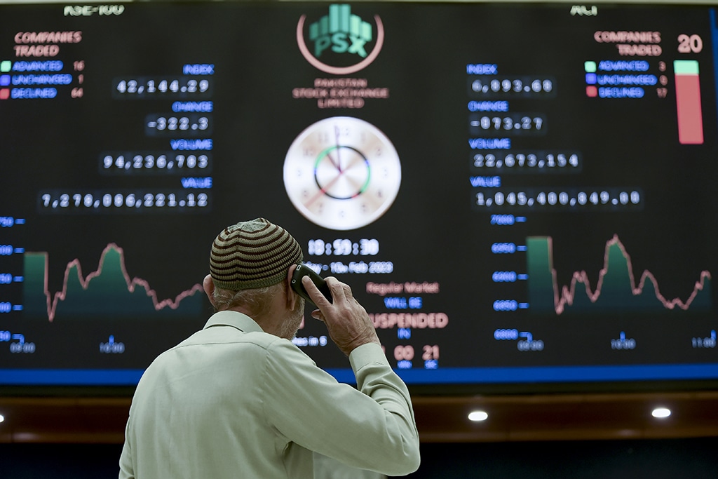 KARACHI: A broker talks on phone as he looks an index board showing the latest share prices at the Pakistan Stock Exchange in Karachi on February 10, 2023. - AFP