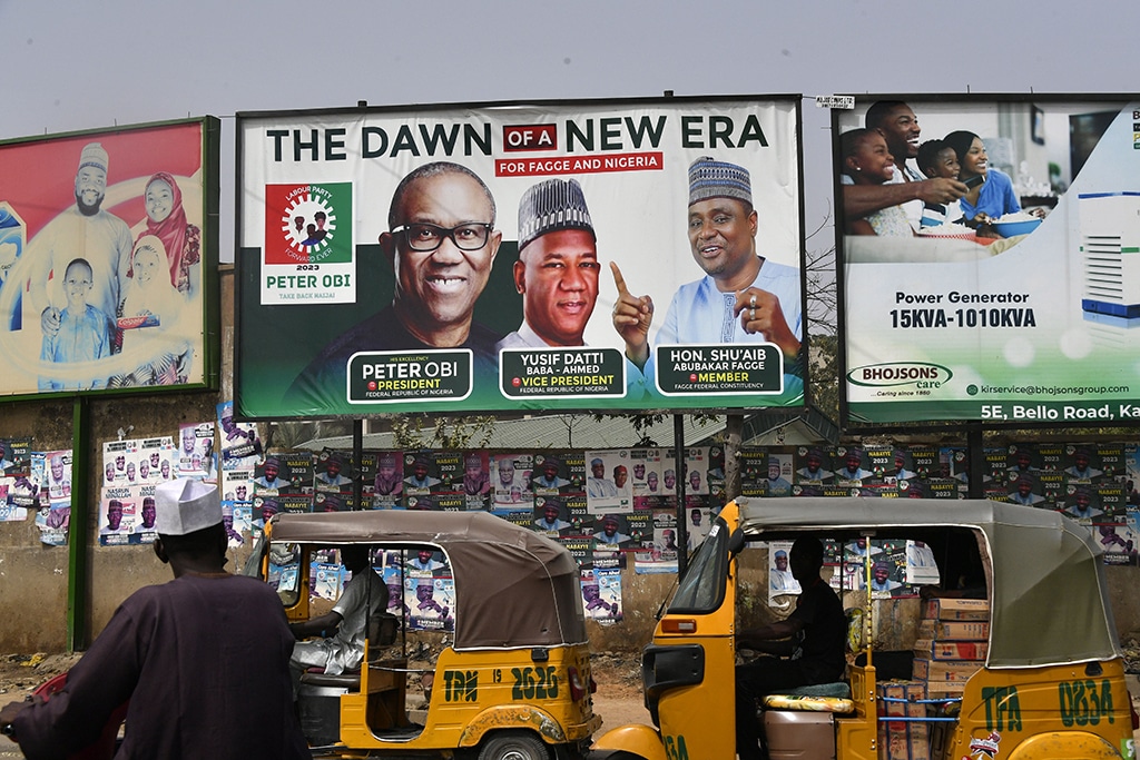 KANO: Rick-shaws drive past a campaign billboard of the candidate of Labour Party Peter Obi and runningmate Datti Baba-Ahmed displayed along the road in Kano, northwest Nigeria. Africa's most populous country has been crippled by fuel shortages for weeks, and cash dispensers are running empty after a sudden currency swap two weeks ahead of Nigeria's presidential election. – AFP