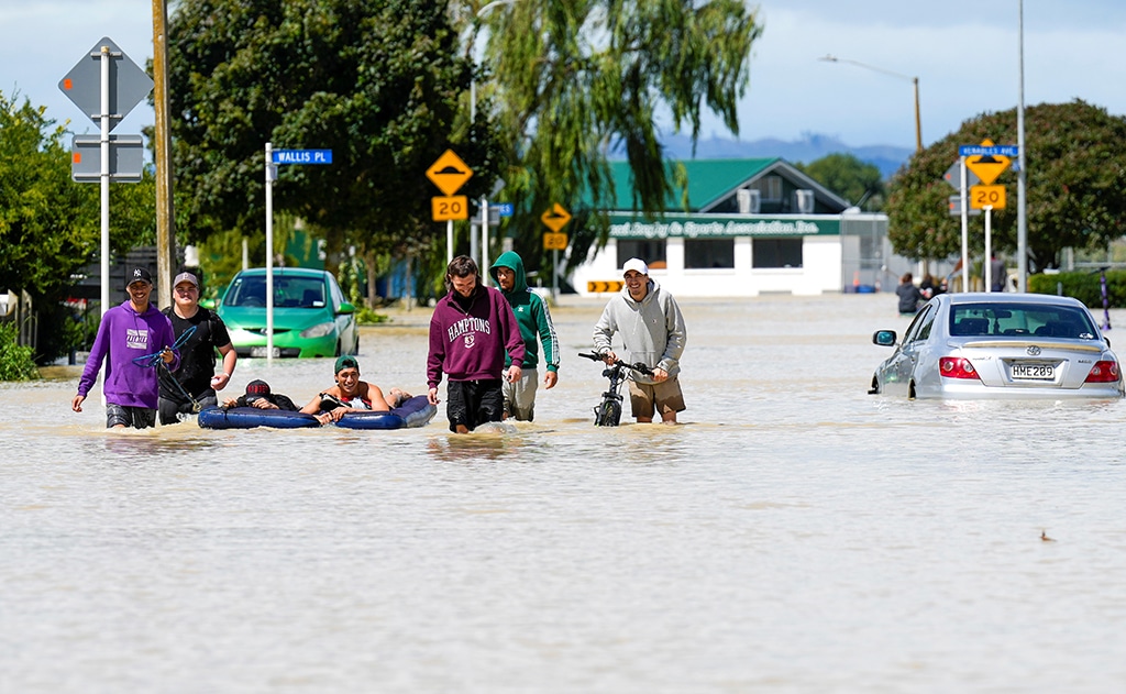 NAPIER: Photo shows people wading through flood waters in the city of Napier, situated on the North Island's east coast. Authorities on February 15 confirmed three deaths after Cyclone Gabrielle cut a trail of destruction across northern New Zealand. – AFP