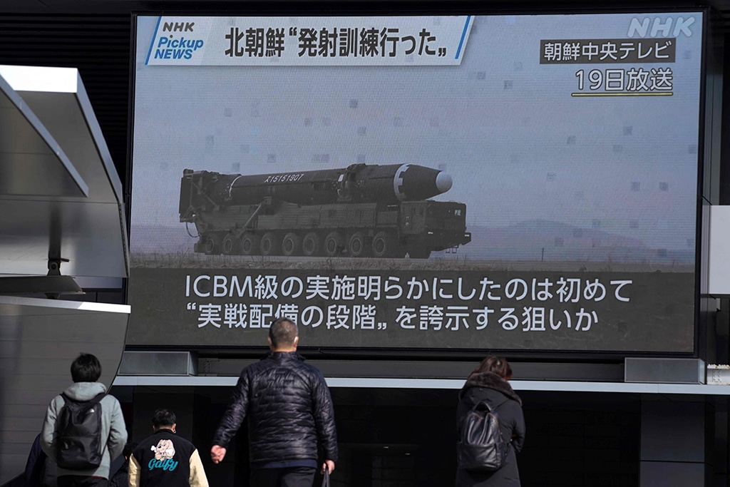 TOKYO: Pedestrians walk past a screen in Tokyo on February 20, 2023, displaying North Korea's missile launch footage broadcasted by Korean Central Television on February 19. - AFP