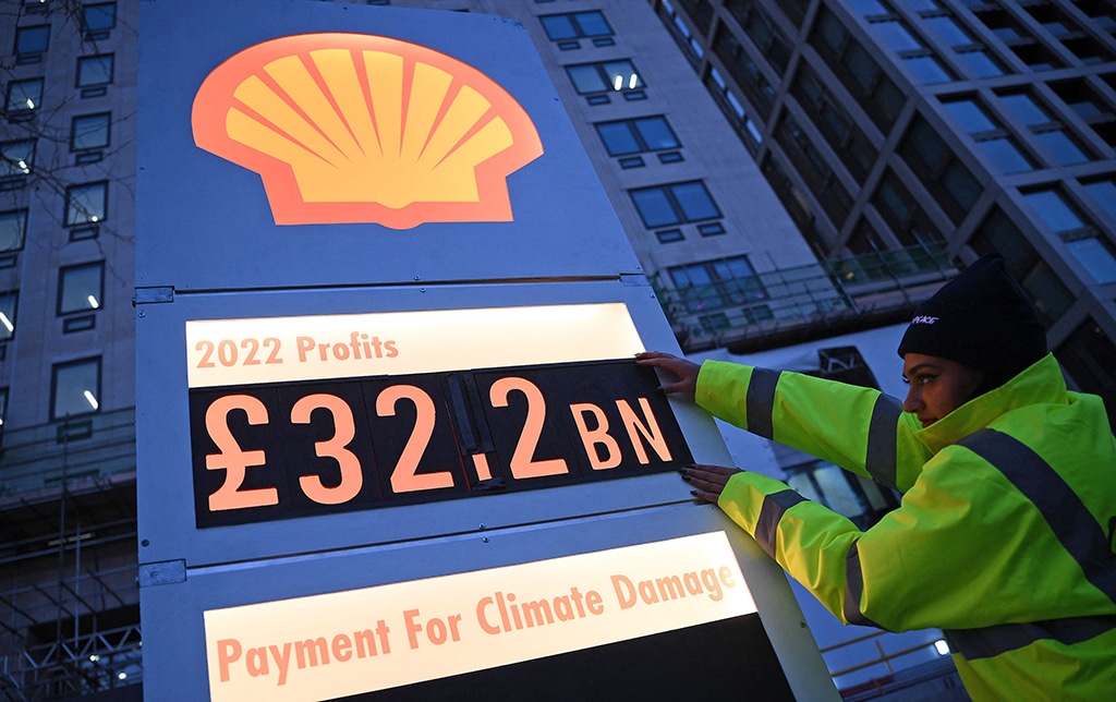 LONDON: Activists from Greenpeace set up a mock-petrol station price board displaying the company's net profit for 2022, as they demonstrate outside the headquarters of Shell, in London. – AFP