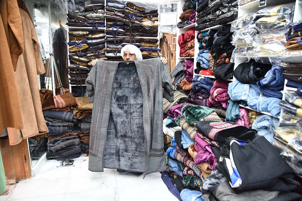 KUWAIT: A vendor displays a winter abaya at the bisht market in Souq Mubarakiya. - Photo by Fouad Al-Shaikh