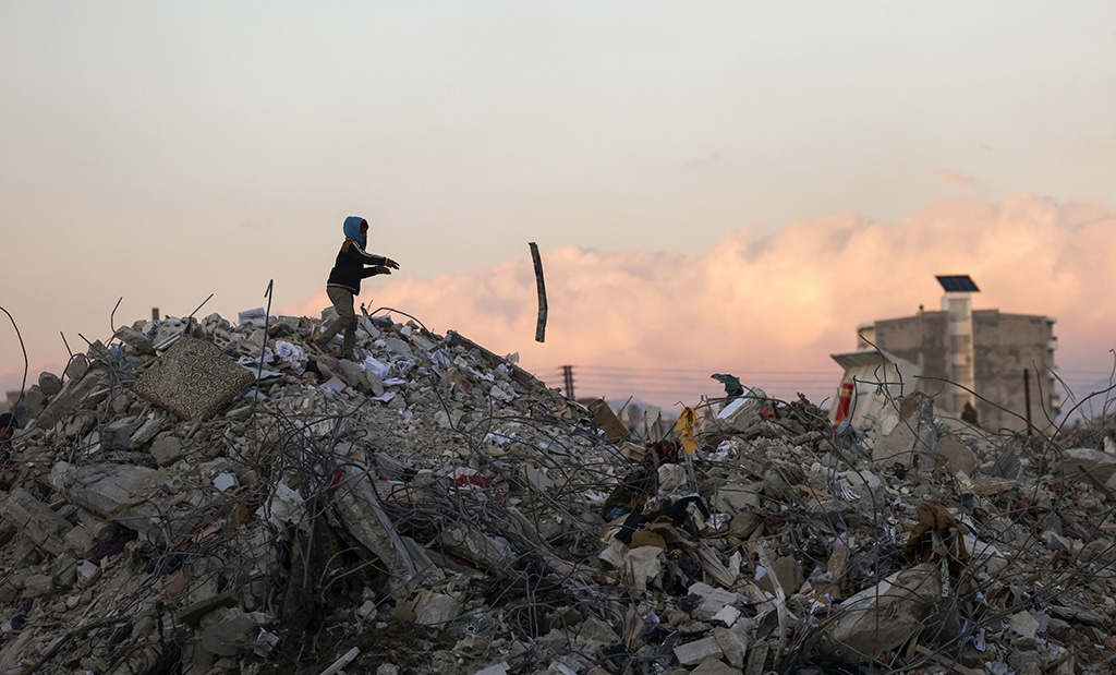 JABLEH, Syria: A Syrian boy searches building rubble for items to salvage in the regime-controlled town of Jableh on February 10, 2023. – AFP photos