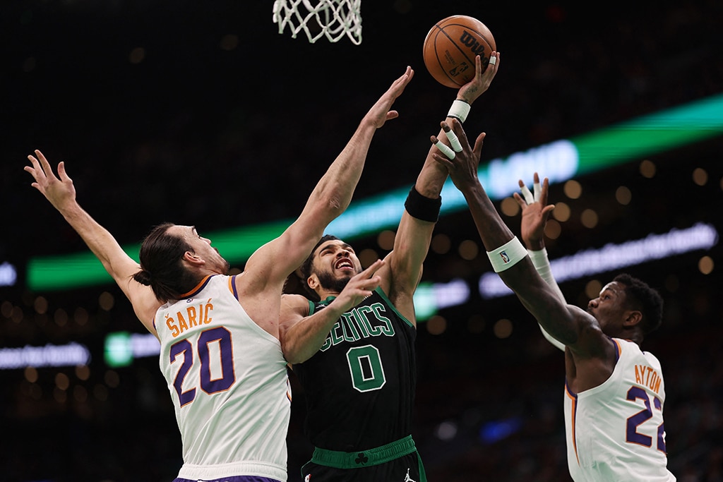 BOSTON: Jayson Tatum #0 of the Boston Celtics takes a shot against Dario Saric #20 of the Phoenix Suns and Deandre Ayton #22 at TD Garden on February 03, 2023.- AFP