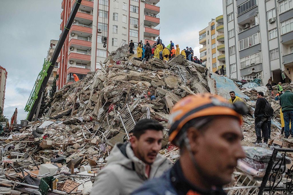 Rescuers search for victims and survivors amidst the rubble of a building that collapsed in Adana in Turkey on Feb 6, 2023 after a 7.8-magnitude earthquake struck the country's southeast. - AFP photos