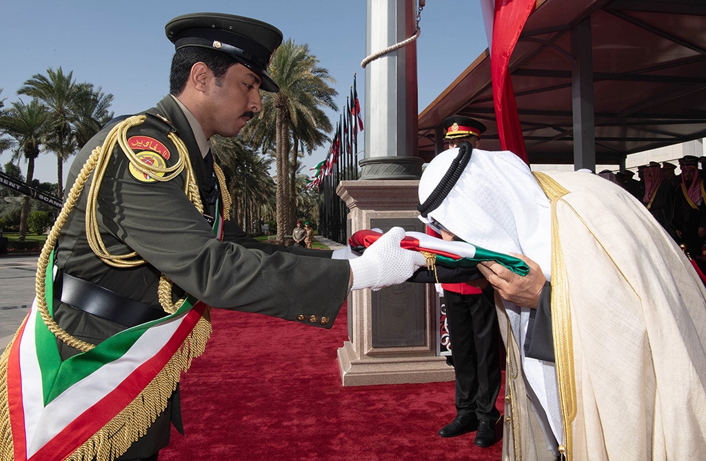 KUWAIT: HH the Crown Prince Sheikh Mishal Al-Ahmad Al-Jaber Al-Sabah kisses the national flag during a flag-hoisting ceremony at Bayan Palace on Feb 1, 2023. - KUNA