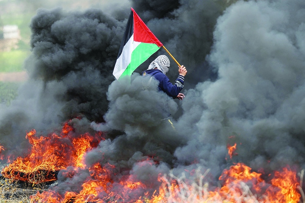 GAZA: Palestinian youths burn tires during a protest near the Gaza border east of Jabalia refugee camp, on February 23, 2023. — AFP