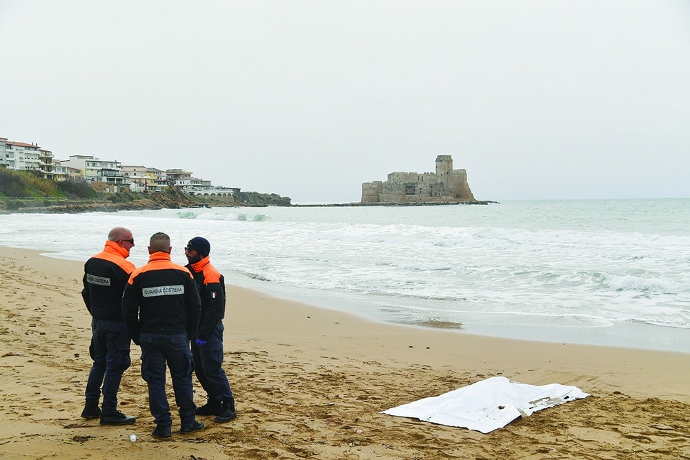 ISOLA DI CAPO RIZZUTO, Italy: Italian coast guard officers stand near a body on Feb 27, 2023 near the beach of Le Castella after a migrant boat sank off Calabria. - AFP