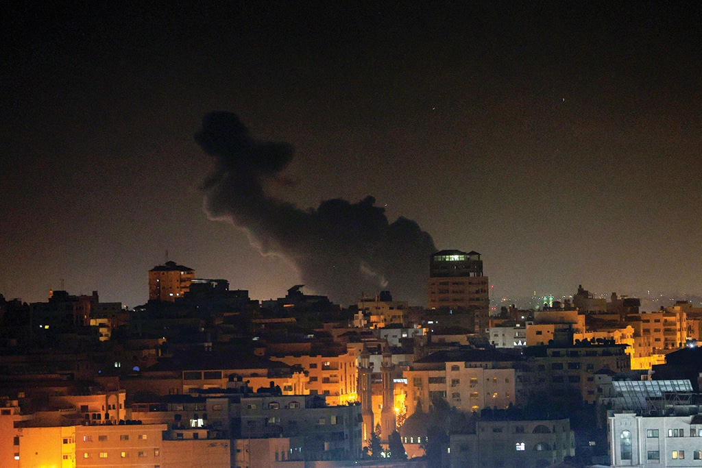 GAZA CITY: Smoke rises above buildings in Gaza City as Zionist entity launched air strikes on the Palestinian enclave early on February 2, 2023. Zionist entity conducted air strikes on the central Gaza Strip hours after intercepting a rocket fired from the Palestinian territory. - AFP