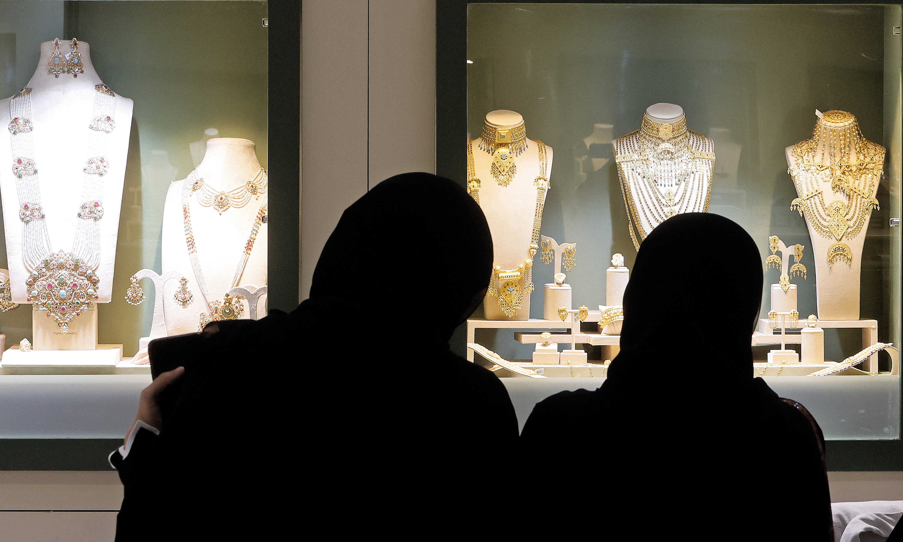 Women check gold sets and pendants at the Doha Jewellery and Watches Exhibition in Doha. —AFP photos