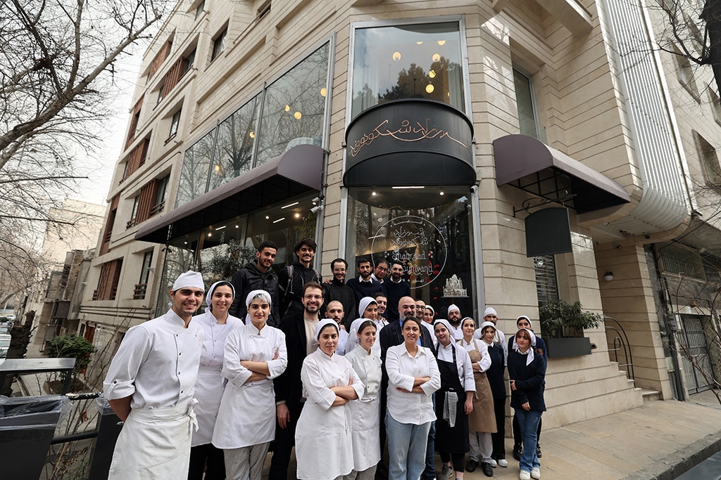 Iranian pastry chef Shahrzad Shokouhivand, poses for a picture with members of her team in front of her luxury pastry shop in Tehran.— AFP photos