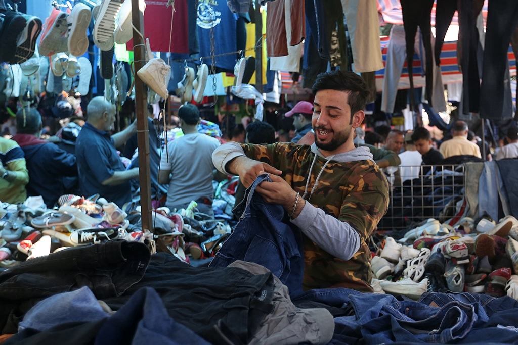 People shop at a flea market in Baghdad. -AFP photosn