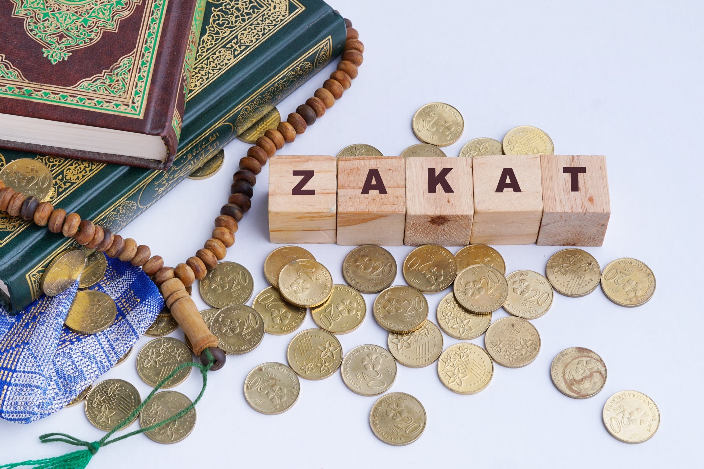 Zakat are charity taken for the poor few days before the end fasting in the Islamic holy month of Ramadan. Arabic characters translated: Holy Quran, the Holy book of Islam. Zakat Conceptual.