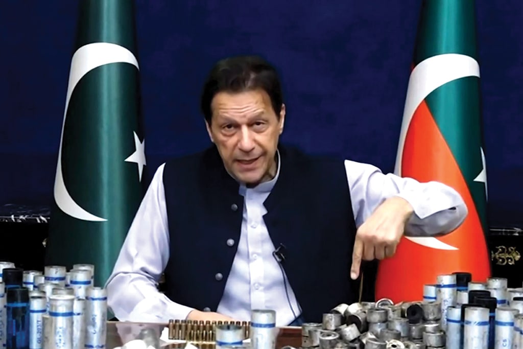 LAHORE: This screengrab from Pakistan Tehreek-e-Insaf via AFPTV taken on March 15, 2023 shows former Pakistan prime minister Imran Khan issuing a video statement with a display of spent teargas canisters that he claims were fired into his home in Lahore. - AFP