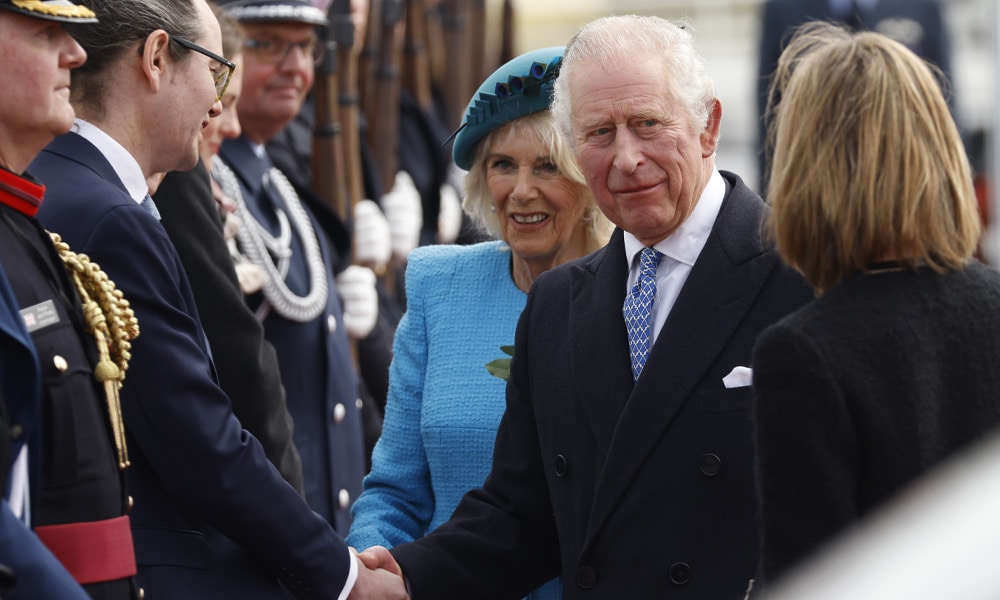 Britain's King Charles III (2R) shakes hands next to Britain's Camilla, Queen Consort and British Ambassador to Germany Jill Gallard (R) after landing at Berlin Brandenburg Airport in Schoenefeld near Berlin, on March 29, 2023. 