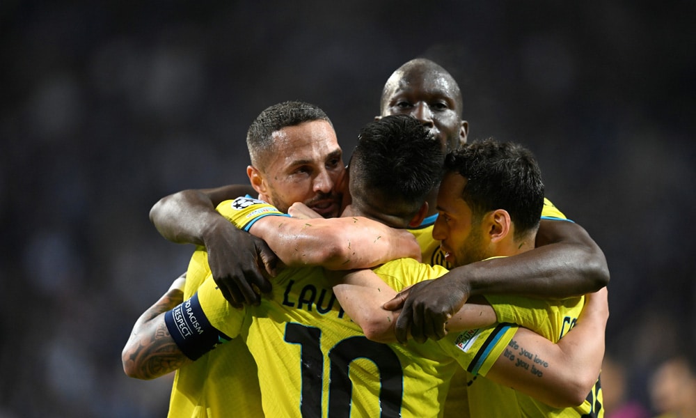 Inter Milan's Argentinian forward Lautaro Martinez (back) and teammates celebrate at the end of the UEFA Champions League last 16 second leg football match between FC Porto and Inter Milan at the Dragao stadium in Porto on March 14, 2023.