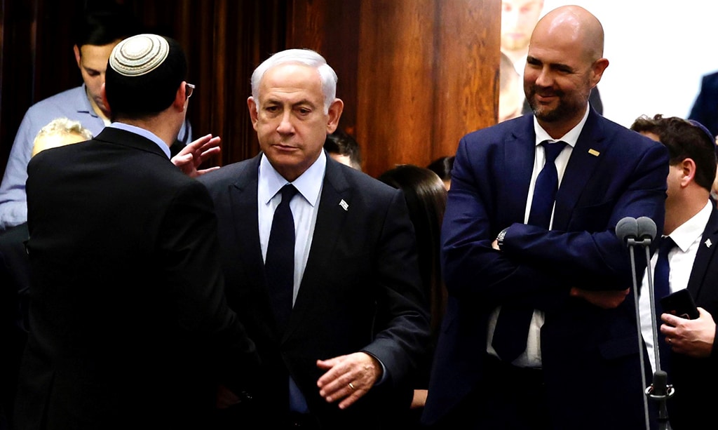 JERUSALEM: Zionist Prime Minister Benjamin Netanyahu (C) stands at the Knesset, Zionist entity's parliament in Jerusalem. Netanyahu announced a pause to divisive judicial reforms moving through parliament, after months of street rallies. – AFPn