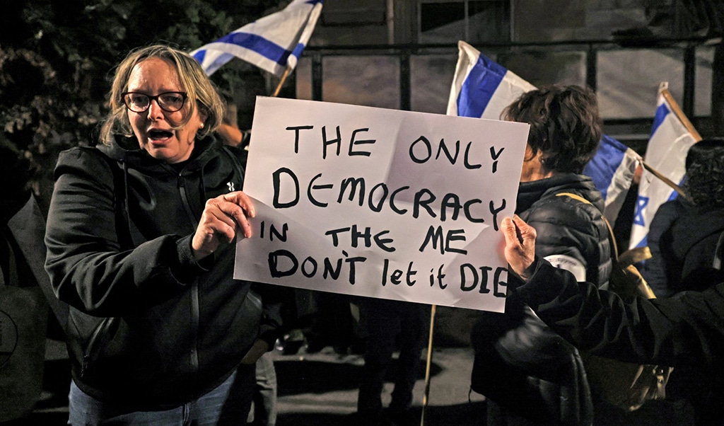 JERUSALEM: Protesters gather with Zionist national flags during a rally against the against the Zionist government's judicial reform, outside the presidential residence in Jerusalem. – AFP