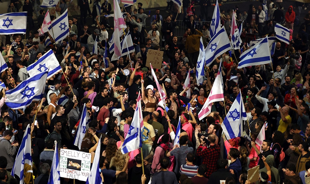 TEL AVIV: Protesters block a road and hold national flags during a rally against the Zionist government's judicial reform in Tel Aviv. – AFP