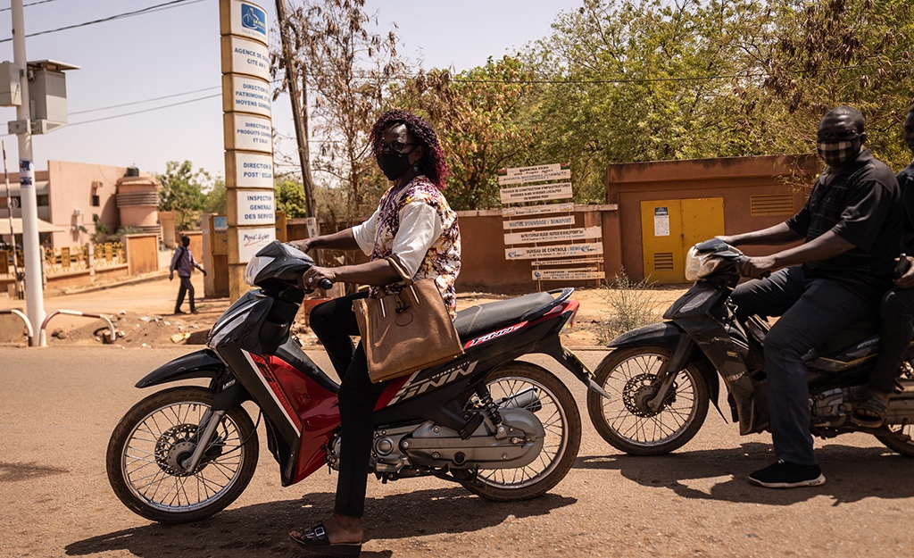 A woman rides a motorcycle in Ouagadougou, on March 2, 2023. – AFP