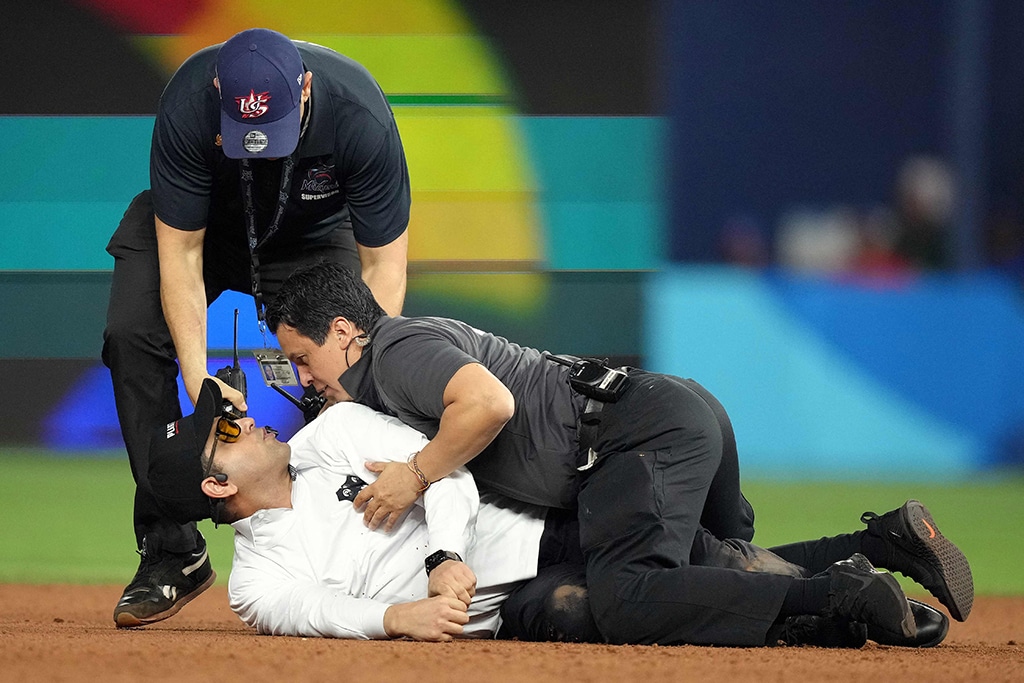 MIAMI: A fan is subdued after running on the field during the World Baseball Classic Semifinals between Team Cuba and Team USA on March 19, 2023 in Miami.- AFP